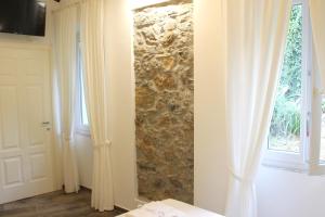 ein Zimmer mit einer Steinmauer neben einer Tür in der Unterkunft Casa Maiò in Riccò del Golfo di Spezia