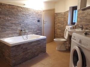 a bathroom with a tub and a toilet and a sink at Case Vacanza Tony in Calatabiano +24 photos