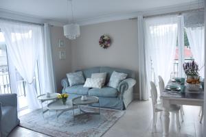 a living room with a blue couch and a table at Apartamenty Magnum in Szklarska Poręba