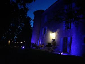 a house lit up at night with purple lights at Chateau de Laric in Chabestan
