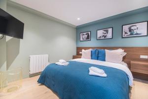 a bedroom with a blue bed with two towels on it at Résidence du Marais - Paris Center in Paris