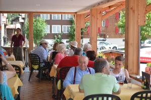 a group of people sitting at tables in a restaurant at Hotel Grimsel in Obergesteln