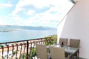 een balkon met een tafel en stoelen en uitzicht op het water bij Apartmani Gaby in Trogir