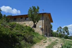 kamienny dom na wzgórzu z drzewem w obiekcie Lo Cel De Tolo w mieście Toló