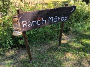 Un cartello di legno che legge "Marca Moriety" sull'erba. di Ranch Mörby a Stora Mellösa