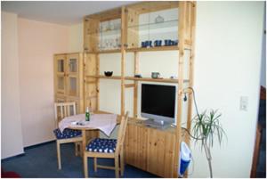 Zimmer mit einem Schreibtisch, einem TV und einem Tisch. in der Unterkunft Haus Nordlicht in Helgoland