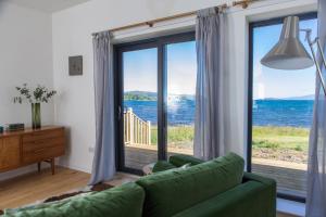 ブロードフォードにあるStay on the Bay, Skyeのリビングルーム(緑のソファ、大きな窓付)