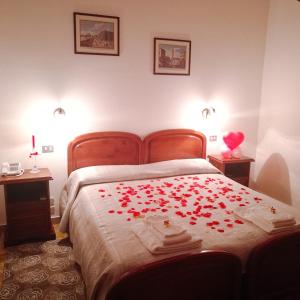 a bedroom with a bed with red roses on it at PARADISO Hotel Ristorante in Reggio Calabria