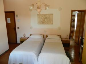 a row of three beds in a room at B&B Casa Fedora in Montecatini Terme