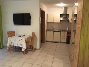 a kitchen with a table and chairs and a television at Boardinghouse Casita Amann in Friedrichshafen