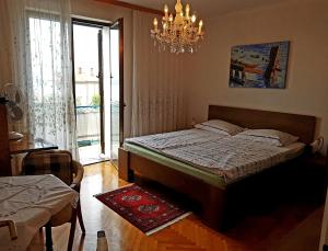 a bedroom with a bed and a chandelier at B&B Family Skvor in Portorož