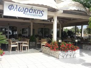 un restaurante con mesa, sillas y flores en Hotel Florakis en Livanátai