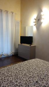 1 dormitorio con cama y vestidor con TV en B&B LE AGAVI, en Borso del Grappa