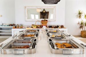 a kitchen with several trays of food on a counter at Paros Agnanti Resort & Spa in Parikia
