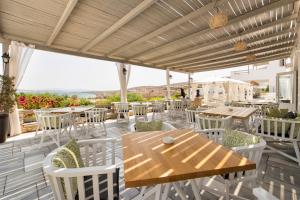 a patio with a wooden table and chairs on a deck at Paros Agnanti Resort & Spa in Parikia