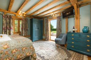 a bedroom with a bed and a dresser and a window at Corner Farm in Halesworth
