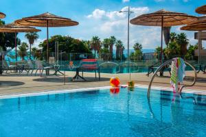 una piscina con sillas y sombrillas en Leonardo Hotel Tiberias, en Tiberíades