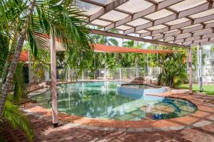 a large swimming pool with an umbrella in a yard at Nightcliff Foreshore Getaway - McKay Gardens in Nightcliff