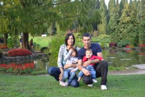 una familia sentada en el césped frente a un estanque en Agriturismo Colombarola, en Sona