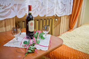 a bottle of wine and two glasses on a table at Smyrecek-centrum Bukowiny in Bukowina Tatrzańska