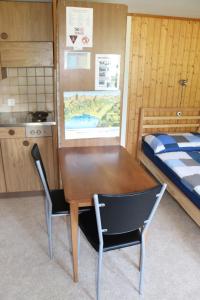 a wooden table and chairs in a room with a bed at Homestay Brienz in Brienz