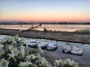 um grupo de barcos na água ao pôr do sol em Le Saline Suites em Carloforte