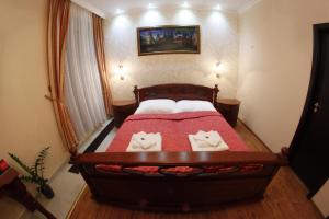 a bedroom with a bed with two cat pillows on it at Alnus Penzion in Smilno