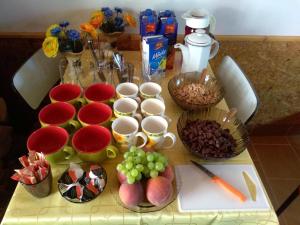 stół z kubkami i miseczkami jedzenia i owoców w obiekcie Apartmány Horalka w Liptowskim Mikulaszu