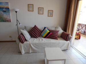 ロス・クリスティアーノスにあるPlaya Lux Los Cristianosのリビングルーム(白いソファ、カラフルな枕付)