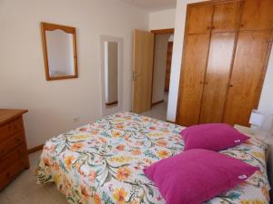 ロス・クリスティアーノスにあるPlaya Lux Los Cristianosのベッドルーム(紫色の枕が付くベッド付)