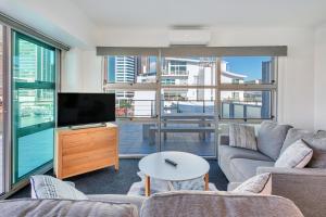 a living room with a couch and a tv at Stunning Harbour & City View Studio l AIRCON & WIFI in Auckland