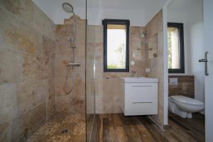 a bathroom with a shower and a sink and a toilet at Hôtel confidentiel Le Grecale in Pianottoli-Caldarello