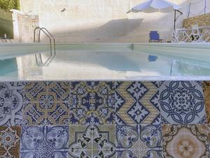 a swimming pool with a tile floor and a swimming pool at Residence del Golfo in Castellammare del Golfo