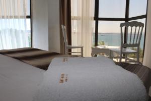 a bedroom with a bed with a view of the ocean at Çeşme Farm Hotel in Çeşme