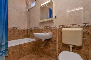 y baño con aseo y lavamanos. en Apartments Roza, en Makarska