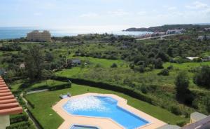 an aerial view of a swimming pool in a field with the ocean at Sea Moments Apartments in Portimão