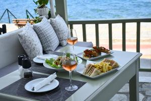 a table with plates of food and glasses of wine at Akro Rooms in Agios Ioannis Pelio