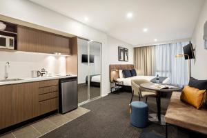 a hotel room with a kitchen and a bedroom at Quest Maribyrnong in Maribyrnong