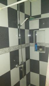 a bathroom with a shower with black and white tiles at Apartman Daris&Emma in Bihać