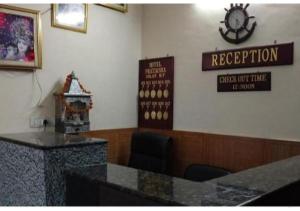 a waiting room with a counter and a clock on the wall at Hotel Pratiksha in Solan