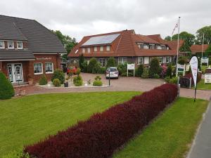 ein Haus mit einem Auto in der Einfahrt in der Unterkunft Café Hausnordlicht - Ferienwohnung 1 in Dornum