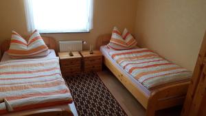 2 Betten in einem kleinen Zimmer mit Fenster in der Unterkunft Café Hausnordlicht - Ferienwohnung 1 in Dornum