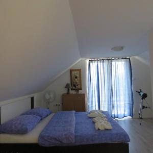 - une chambre avec un lit doté de draps bleus et une fenêtre dans l'établissement Apartment Metlača, à Perušić