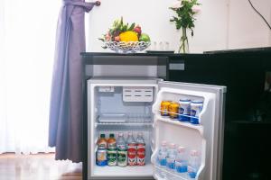 an open refrigerator filled with drinks and a bowl of fruit at Blue Star Hotel in Nha Trang