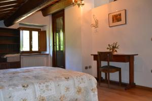 a bedroom with a bed and a table and a desk at B&B Il Palazzo in Sansepolcro