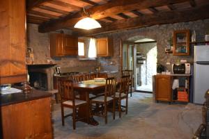 een keuken met een tafel en stoelen en een koelkast bij B&B Il Palazzo in Sansepolcro