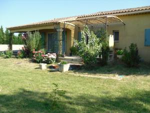 una casa con un jardín delante de ella en Gite au coeur de Provence en LʼIsle-sur-la-Sorgue