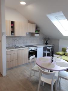 a kitchen and dining room with a table and chairs at Apartments Zagy in Hrvatski Leskovac