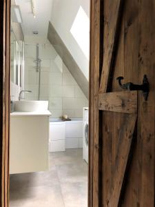 uma casa de banho com um lavatório e uma porta de madeira em Pokoje Gościnne Parkowa 2 em Świeradów-Zdrój