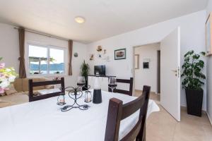 a dining room and living room with a table and chairs at Villa sea oasis Ratac in Slano